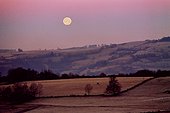 Coucher de Lune à l'aube rosée après éclipse totale lunaire ; La Lune s'apprète à se coucher alors que les lueurs de l'aube colorent le ciel de rose. A la pleine Lune, la Lune se couche quand le Soleil se lève. Cette image a été prise à la fin de l'éclipse totale lunaire du 20 janvier 2000, ce qui explique la teinte jaune pâle de la Lune.