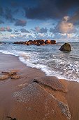 Pink granite and sand beach at sunrise France