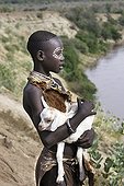 Karo young girl carrying a young goat Ethiopia