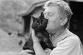 Femme embrassant avec tendresse un chat noir