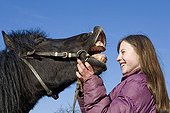 Teenager with her pony neighing France