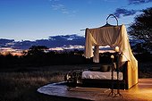 Bed on a terrace at sunset in a luxury lodge Namibia