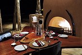 Table next to a blazing fireplace in a luxury lodge Namibia