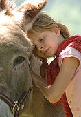 Moment de tendresse entre un âne et une jeune fille France ; La photographie a été prise lors d'une randonnée à dos d'ânes.