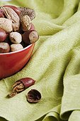 Red porcelain bowl filled with assorted nuts