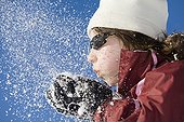 Girl blowing on the snow in her hands Morzine