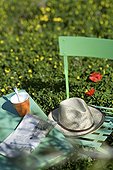 Straw hat and newspaper on garden furniture in Provence