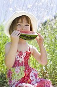 Petite fille de trois ans qui mange un quartier de Pastèque