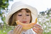 Petite fille de trois ans qui mange un quartier de Melon