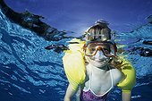 Girl learning to swim with armbands in a pool France