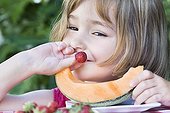 Girl before a slice of melon and strawberries  ; The girl aged 4