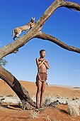 Young San girl with Caracal on tree stump Namibia ; In the private reserve named "N/a’an ku sê", welfare programs and health support converge to maintain populations of Bushmen in good health and to reintroduce the wild Cheetahs. This nomadic group of hunter-gatherers has a history dating back over 20,000 years. Their close relationship and perfect their knowledge of animals allowed to live and feed in the deserts of southern Africa.