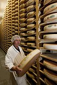 Cave ripening cheese Comté in the Jura France ; The master cheesemaker returns manually cheese wheels 