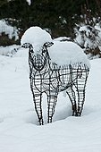 Sheep statue in a garden under snow