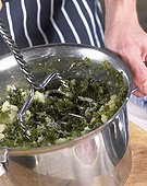 Mashing curly kale and potatoes for hotchpotch