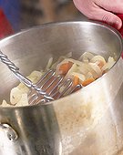Mashing carrots, potatoes and onions for hotchpotch