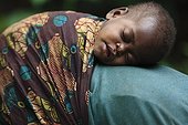 Pygmy Baaka child asleep on her mother Cameroon