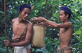 Young tribesmen with basket of wild mangos Sumatra ; Suku Anak Dalam tribe<br>