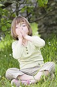 Girl blowing a whistle made from a blade of grass  ; Girl aged 5 years 