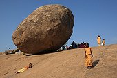 Children playing slide in Mamallapuram India ; This rock is called the ball of butter of Krishna Mamallapuram