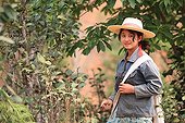 Masked woman picking tea in Burma