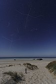 Three Beautiful of summer over a sandy beach ; At the end of August night, the Three Beautiful of Summer are visible to the west: Deneb of Cygnus, Vega in Lyra and Altair in Aquila. The arrow pierced his wing. The Dolphin is visible on the left.