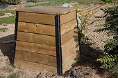 Wooden compost container in an organic garden