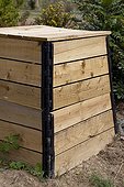 Wooden compost container in an organic garden