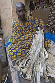 Man and articles snakeskin on a stall Bamako Mali