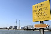 Billboard ban & Fessenheim Nuclear Power Plant France ; Overlooking the Grand Canal of Alsace on the Rhine channeled. A pannel prohibiting fishing activities. Commissioned in 1977, it's the oldest operational nuclear power plant in France.