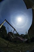 Girl swinging in a solar halo of 22 ° radius 