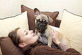 Woman and French Bulldog on a couch France  ; Age: 8 months 