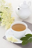 Elderflower and elderberry herbal tea in a white cup