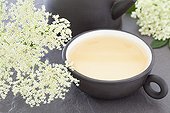 Elderflower and elderberry herbal tea in a black cup