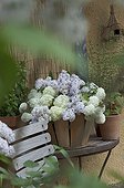 Bouquet of flowers of snowball bush and lilac in a basket
