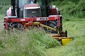 Tractor mowing a meadow in spring Doubs France