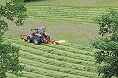 Tractor mowing a meadow in spring Doubs France