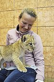 Lion cub in the lap of a woman Zoo Belgrade Serbia ; The Belgrade Zoo specializes in the conservation of species of white or albinos and particularly white lions, a subspecies extremely rare. 