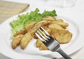 Assiette de country potatoes ; quartiers de pommes de terre ou country potatoes sur une assiette