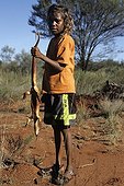 Aborginal girl holding an hunted sand monitor in Australia ; Warlpiri Aborginal community of Alice Spring