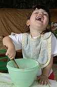 Girl preparing cake batter France ; Age: 3 years