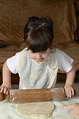 Girl preparing cake batter France ; Age: 3 years