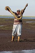 Man holding an Anaconda in the Venezuelan llanos