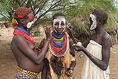 Three young Karo women putting on make-up, facial paintings, Omo river valley, Southern Ethiopia, Africa