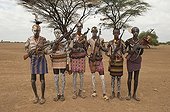 Group of Karo warriors with body and facial paintings holding a rifle over their shoulder, Omo river valley, Southern Ethiopia, Africa