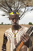 Karo warrior with body and facial paintings holding a rifle, Omo river valley, Southern Ethiopia, Africa