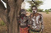 Two Karo warriors with body and facial paintings holding a rifle over their shoulder, Omo river valley, Southern Ethiopia, Africa