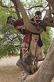 Three Karo children with facial paintings in a tree, Omo river valley, Southern Ethiopia, Africa