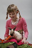 Girl giving a carrot to a rabbit 