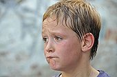 Sceptic and sweaty 8-year-old boy, football yard in Cologne, North Rhine-Westphalia, Germany, Europe
